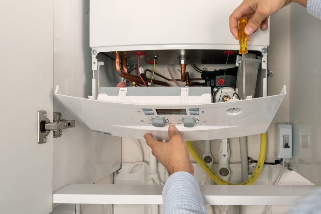 a plumber repairing a heating boiler in Virginia Beach, VA