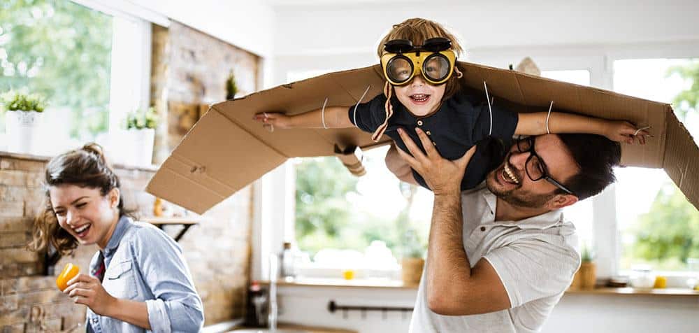 father flying son through the kitchen while mother is laughing